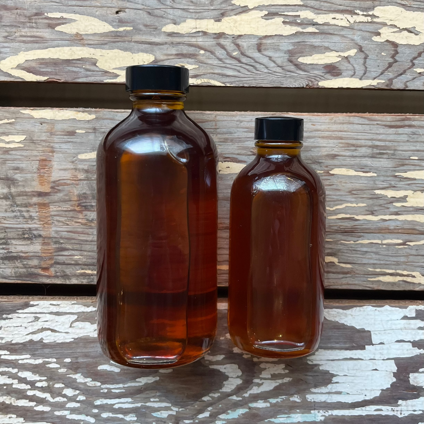 Boiled Linseed Oil, 8oz and 4oz sizes for protecting wooden gardening tool handles, pictured on wooden background