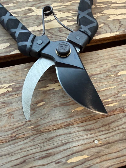 Close-up view of Black Masamune Secateurs open on wooden background