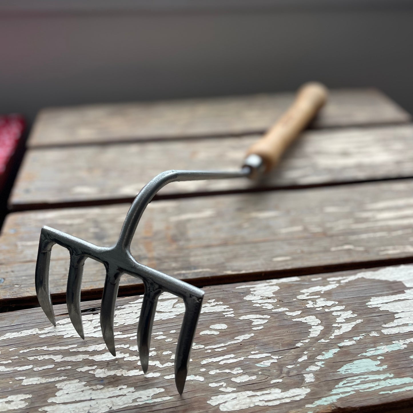 Sneeboer Cherry Hand Rake displayed on wooden crate
