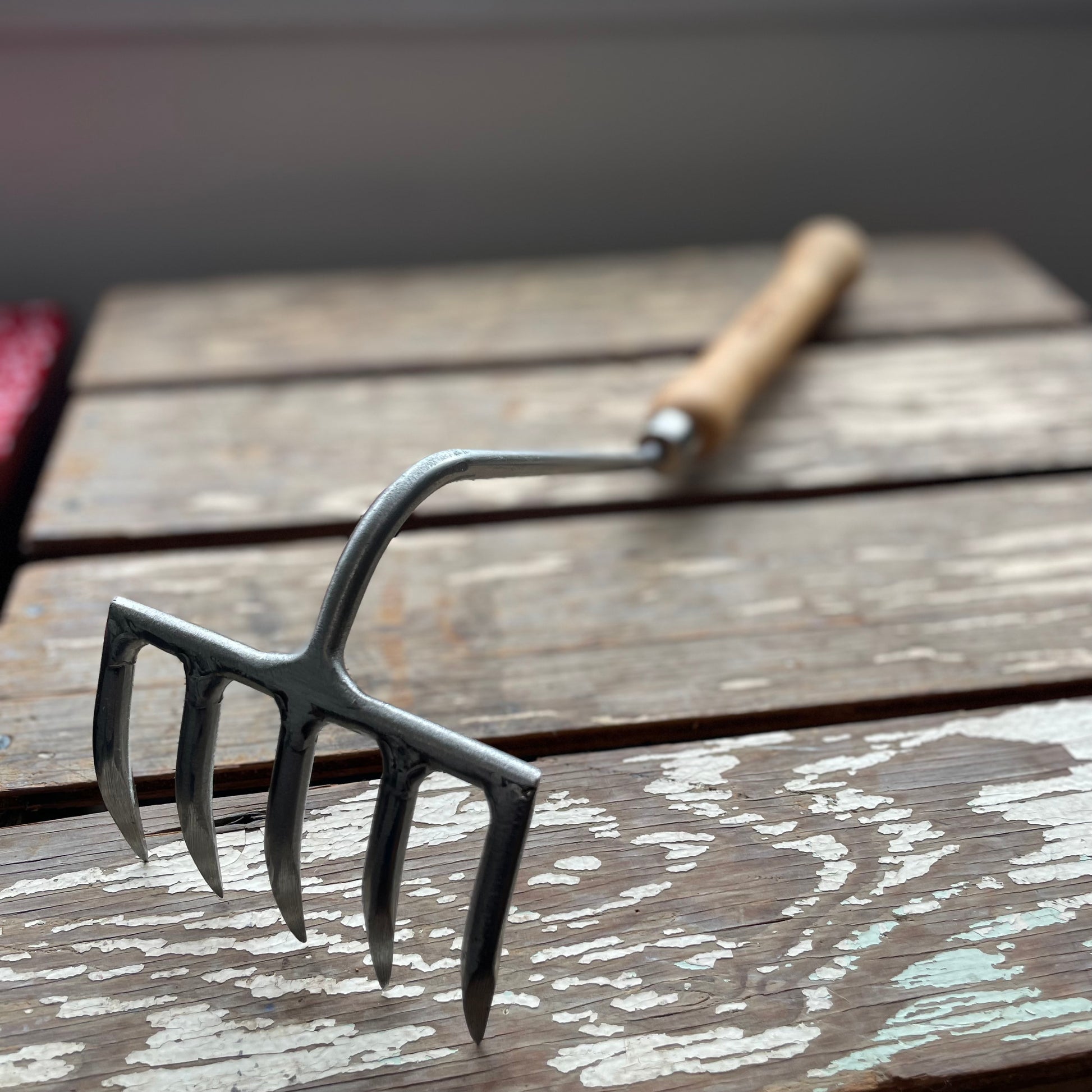 Sneeboer Cherry Hand Rake displayed on wooden crate