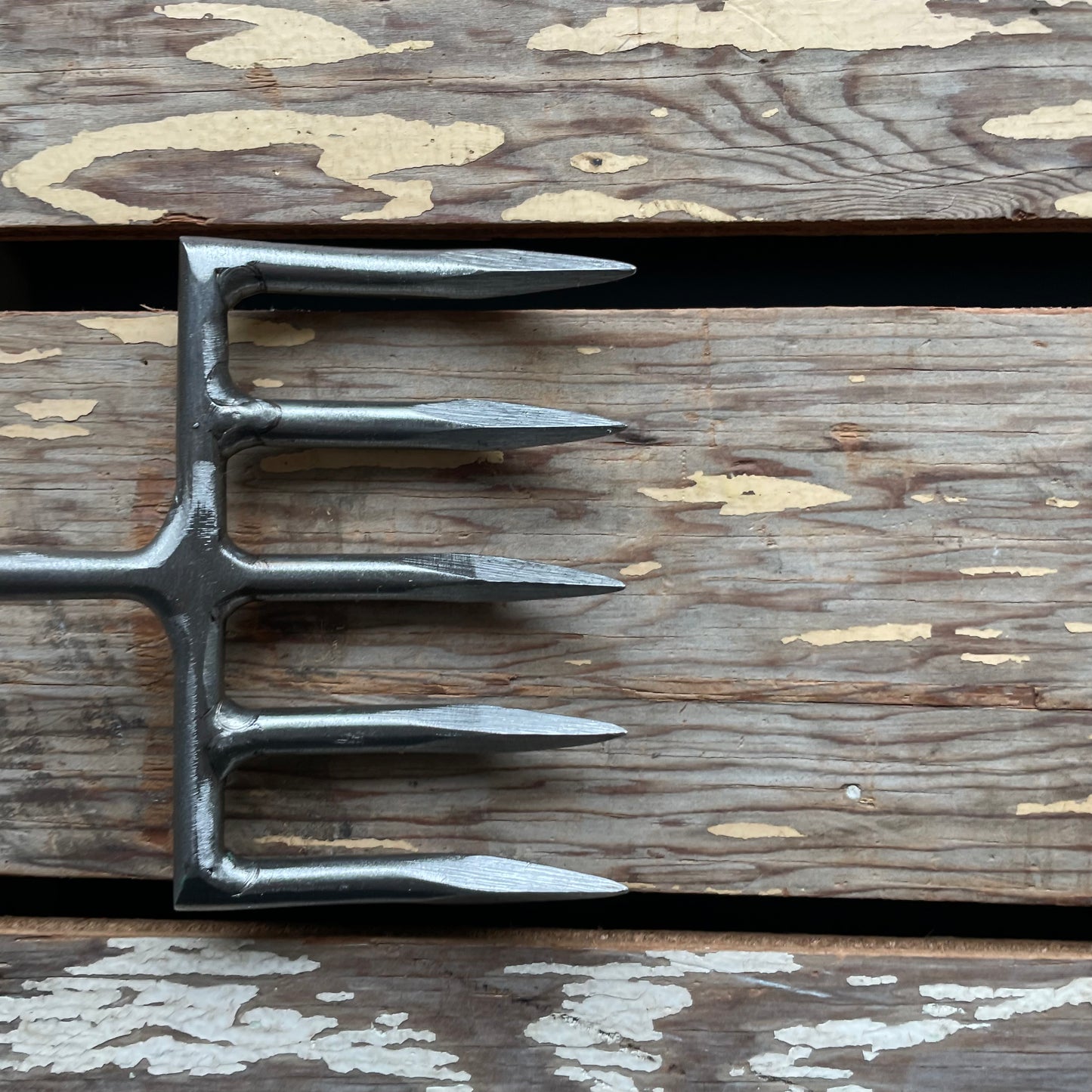 Sneeboer Cherry Hand Rake, close-up of tines, displayed on wooden crate
