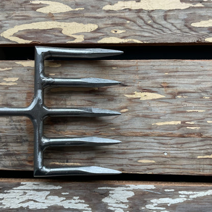 Sneeboer Cherry Hand Rake, close-up of tines, displayed on wooden crate