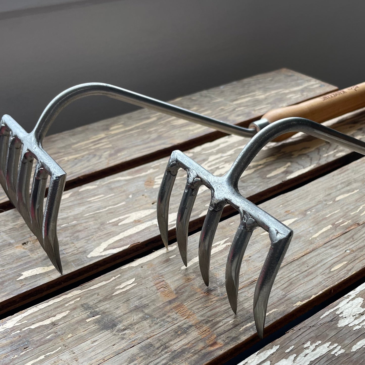 Two Sneeboer Cherry Hand Rakes displayed on wooden crate