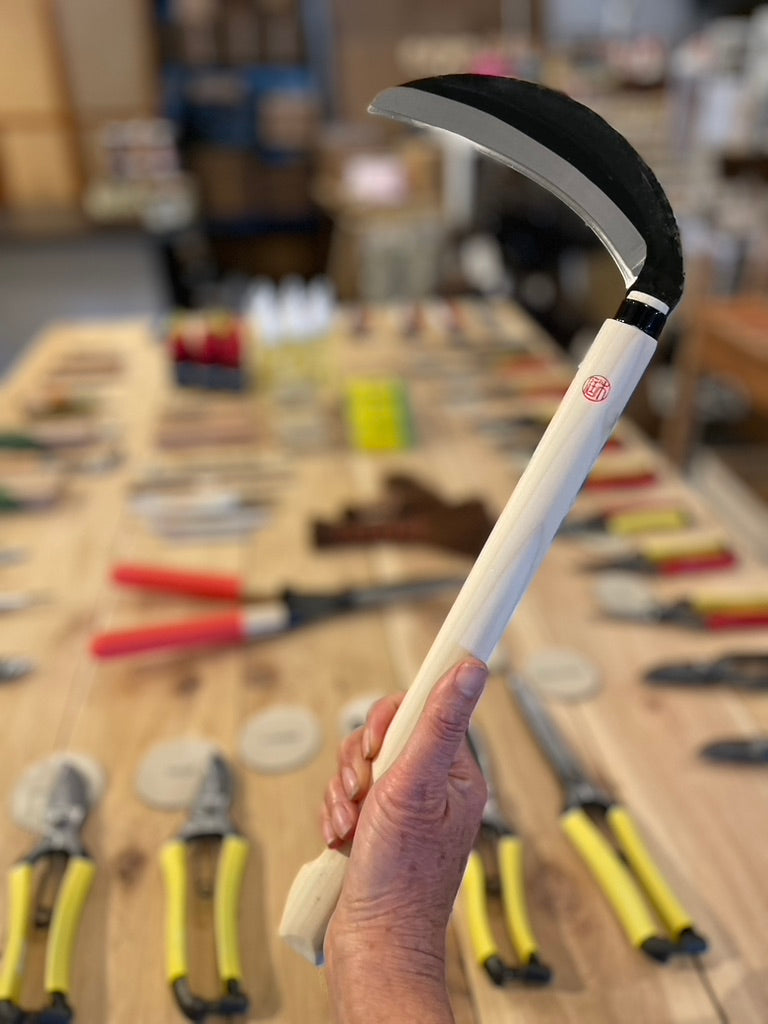 Niwaki Kama Sickle being held in Gardener's Kit showroom