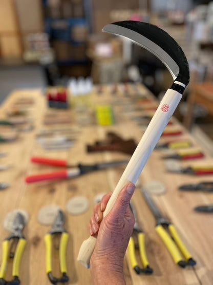 Niwaki Kama Sickle being held in Gardener's Kit showroom