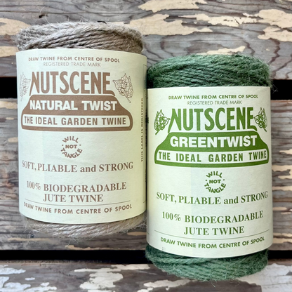 Two spools of Nutscene garden twine, one natural and one green, on a wooden background.