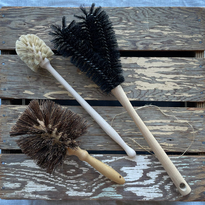 Redecker Lawnmower Brush for cleaning frame and blades of lawnmower pictured with Water Bottle brush and Flowerpot brush on wooden background