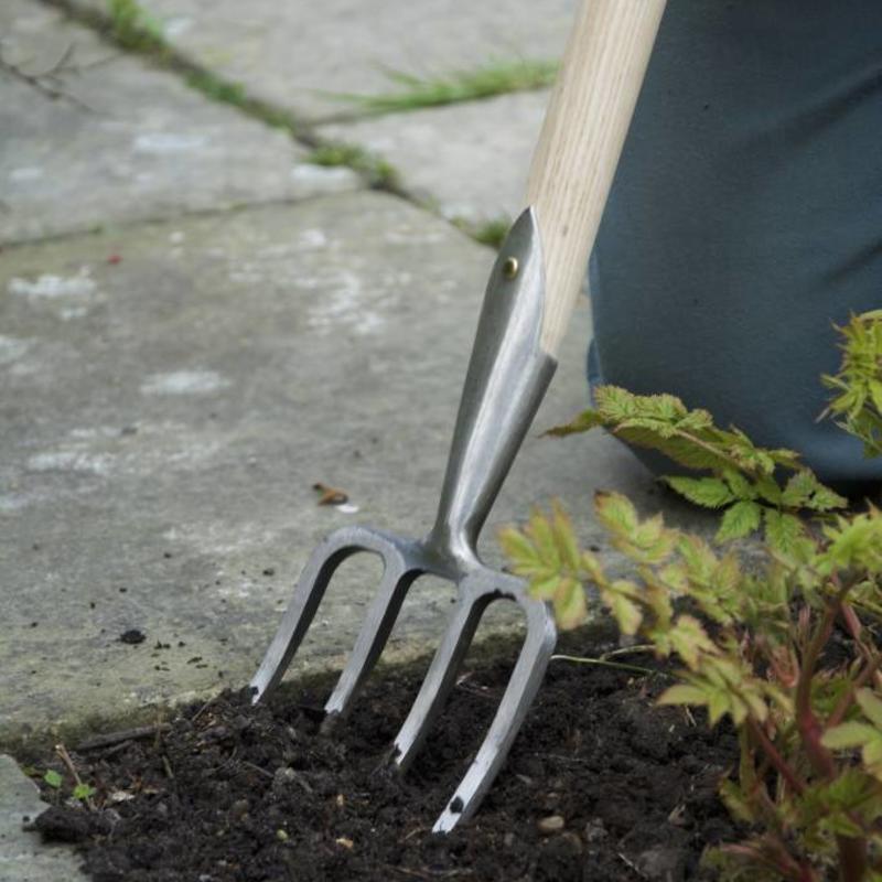 Sneeboer Great Dixter Short Fork being used in garden bed