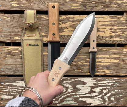 Niwaki Serrated Hori Hori being held overtop of the Niwaki Hori Hori collection