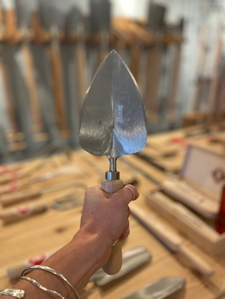 Sneeboer Transplanting Trowel being held up in Gardener's Kit Showroom